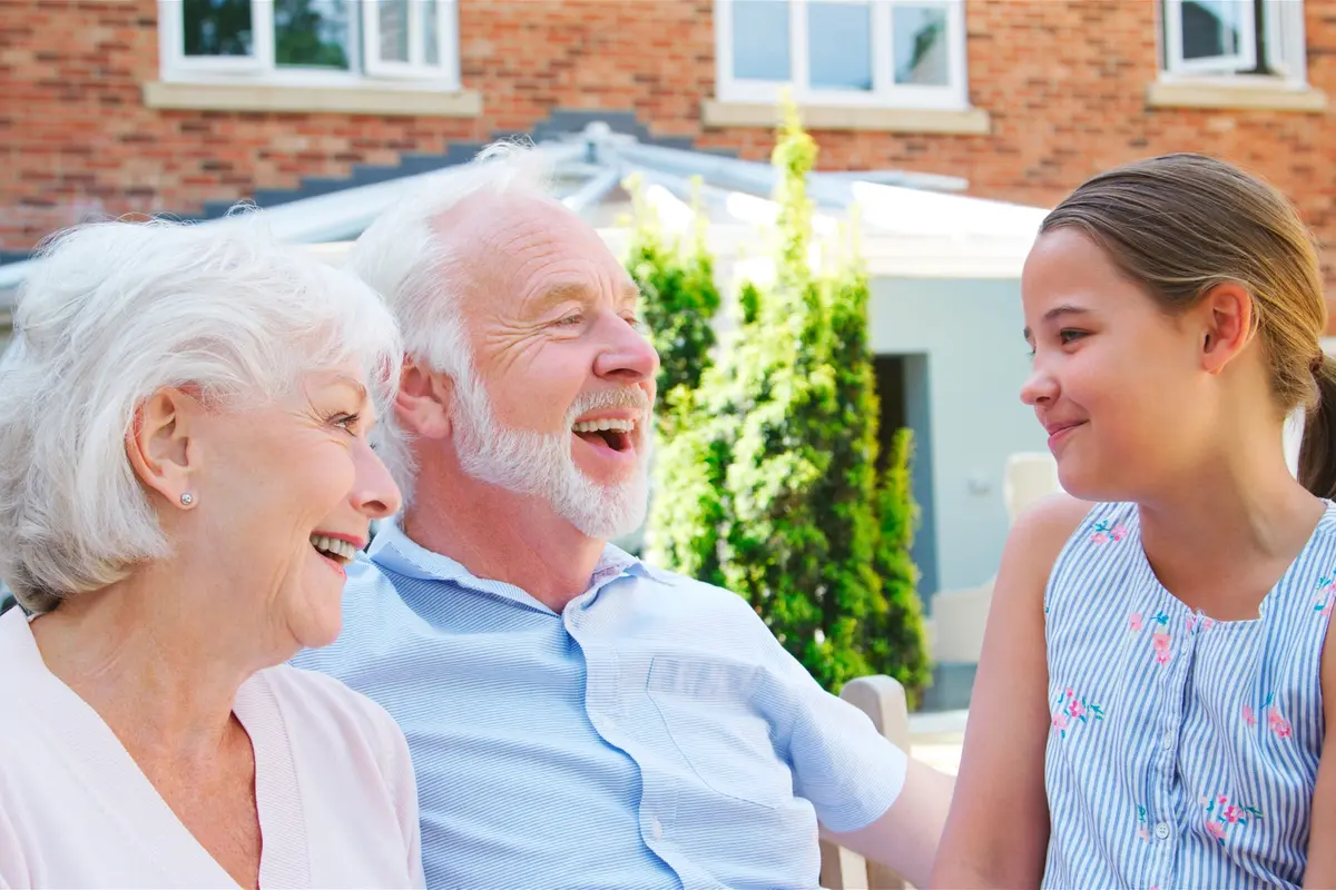 senior-living-in-tampa-palms-legacy-highwoods-preserve senior couple with grad daughter at the Legacy at Highwoods Preserve, a senior living in Tampa