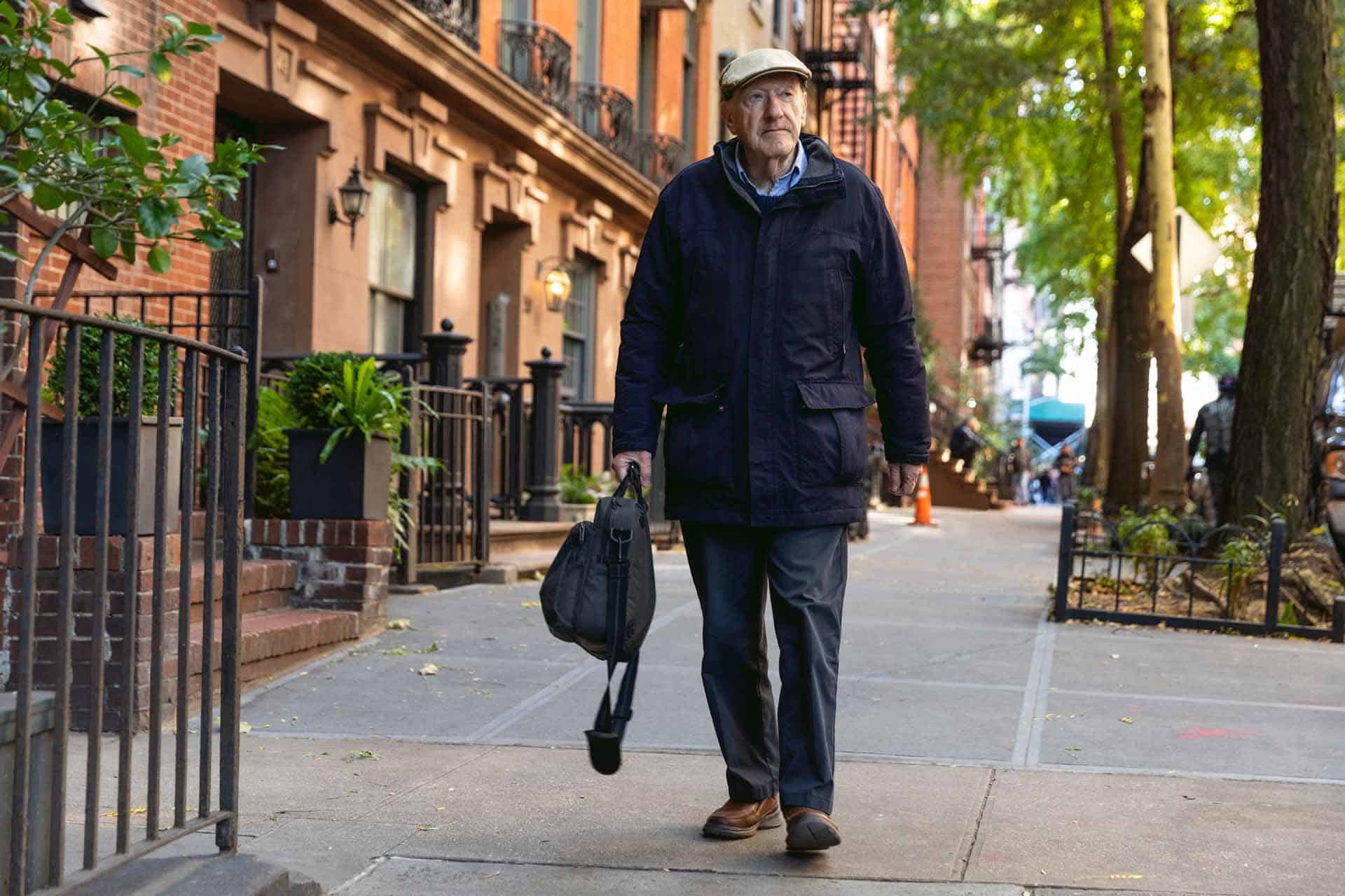 image of elderly man walking on sidewalk